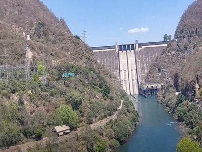 Close-up of Bhakra Dam massive concrete structure with water gushing from spillways